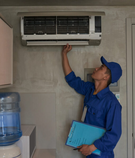 Young Asian technician checking conditioner in kitchen